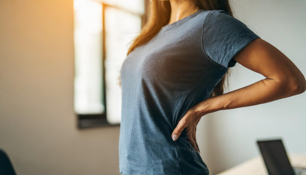 Hiperlordoză Lombară (Spate Curbat): Cauze, Simptome și Tratament | Chiromedica Cluj 2 woman grimaces pain clutching lower back symbolizing discomfort health issues